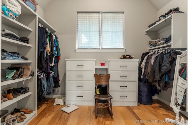 walk in closet featuring lofted ceiling and light hardwood / wood-style flooring