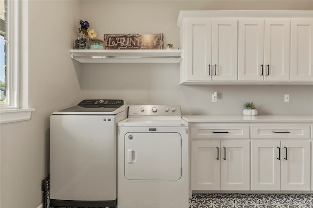 clothes washing area featuring cabinets and washing machine and dryer