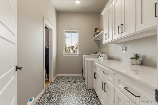 laundry room with washer and dryer and cabinets