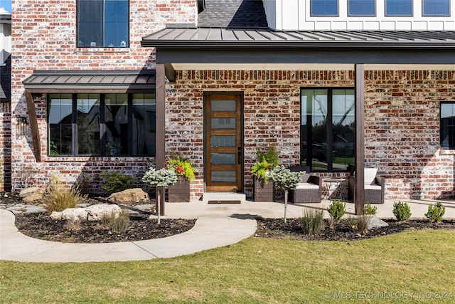 property entrance featuring a lawn