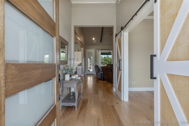 corridor featuring light hardwood / wood-style floors and a barn door