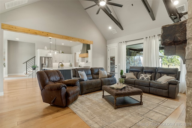 living room with beam ceiling, sink, light wood-type flooring, high vaulted ceiling, and ceiling fan