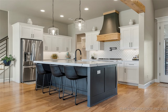 kitchen with premium range hood, light hardwood / wood-style flooring, stainless steel appliances, and white cabinetry