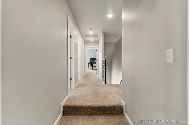 hall with light colored carpet