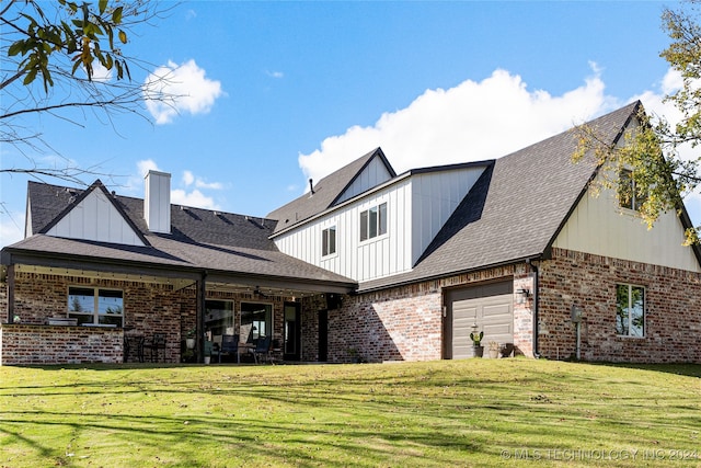 back of house featuring a yard and a garage