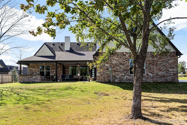 back of house featuring a patio and a lawn