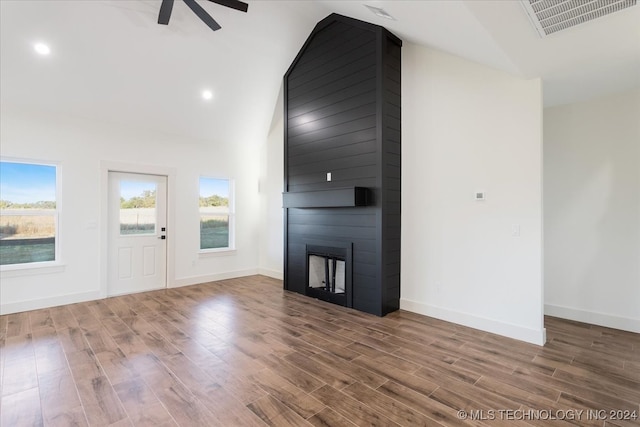 unfurnished living room with hardwood / wood-style flooring, high vaulted ceiling, a fireplace, and ceiling fan