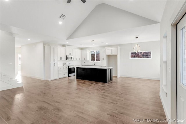 849 Springfield Ct, Durant, OK 74701 - unfurnished living room featuring high vaulted ceiling, light wood finished floors, recessed lighting, baseboards, and healthy amount of natural light