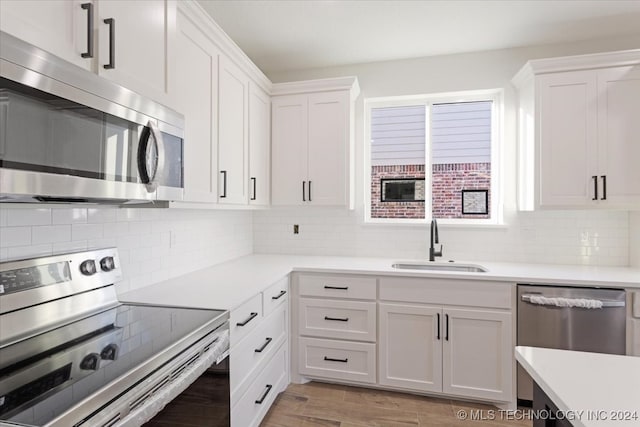 kitchen featuring appliances with stainless steel finishes, light wood-type flooring, and white cabinetry