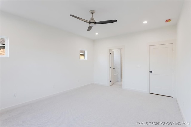 unfurnished bedroom with light carpet, ensuite bathroom, and ceiling fan