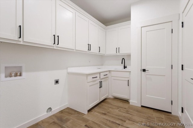 849 Springfield Ct, Durant, OK 74701 - laundry area featuring cabinet space, hookup for an electric dryer, light wood-type flooring, washer hookup, and baseboards