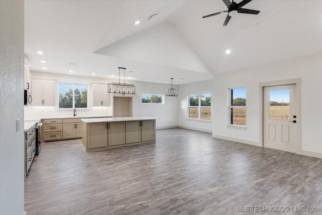 kitchen featuring a kitchen island, light hardwood / wood-style flooring, decorative light fixtures, and high vaulted ceiling