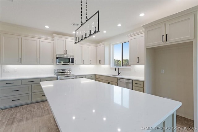 845 Springfield Ct, Durant, OK 74701 - kitchen with stainless steel appliances, a sink, light wood-style flooring, a center island, and recessed lighting