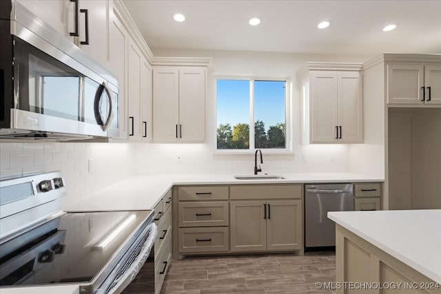 kitchen featuring sink, white cabinetry, decorative backsplash, and stainless steel appliances