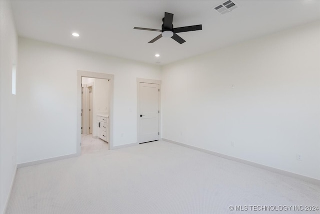 unfurnished bedroom with connected bathroom, light carpet, and ceiling fan