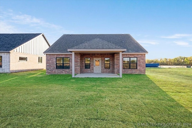 845 Springfield Ct, Durant, OK 74701 - back of house with brick siding, a patio, a shingled roof, and a lawn