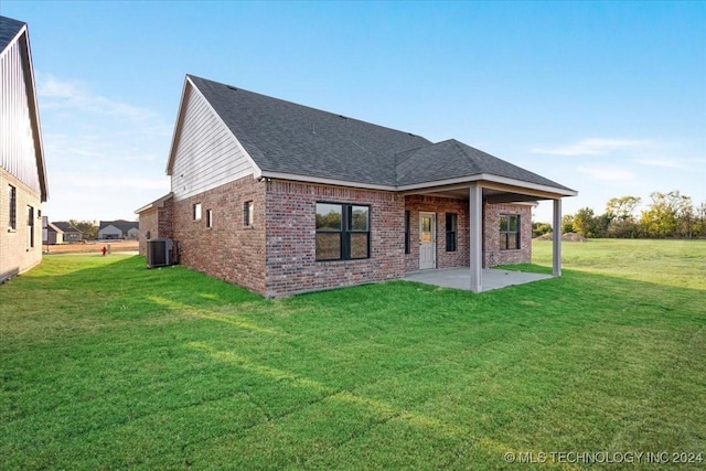 845 Springfield Ct, Durant, OK 74701 - rear view of property with brick siding, central AC unit, a patio, a shingled roof, and a yard
