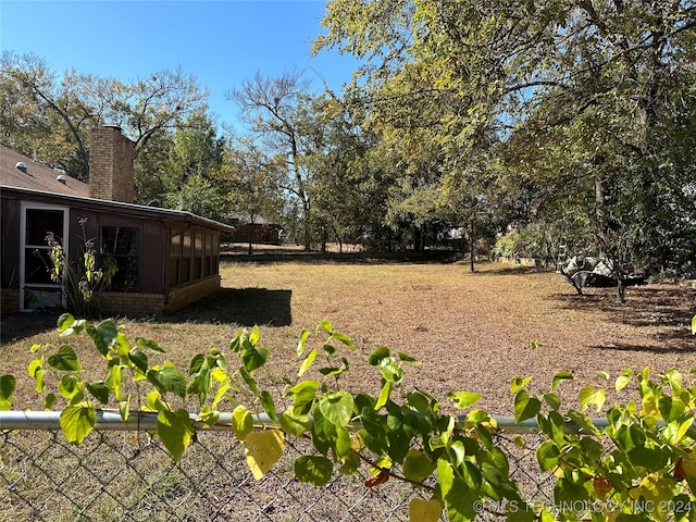 view of yard featuring a sunroom and a rural view