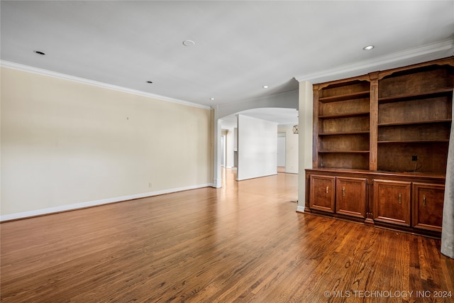 unfurnished living room with ornamental molding and wood-type flooring