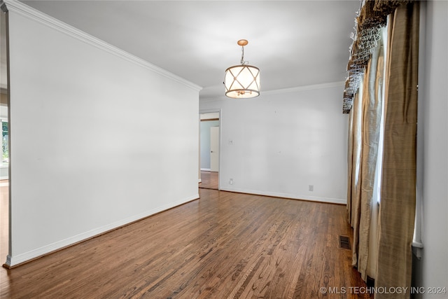 empty room featuring ornamental molding and wood-type flooring