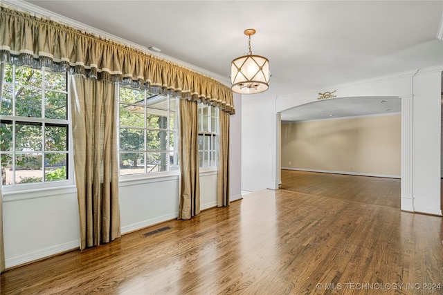 unfurnished dining area featuring ornamental molding and hardwood / wood-style floors