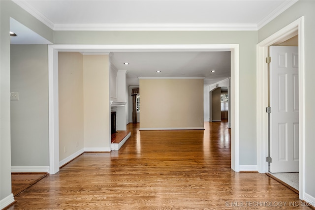 hallway with ornamental molding and hardwood / wood-style flooring