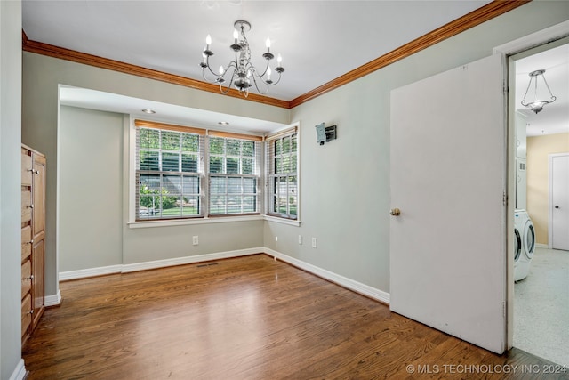 unfurnished room featuring washer / clothes dryer, wood-type flooring, ornamental molding, and an inviting chandelier