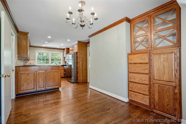 kitchen featuring decorative backsplash, dark hardwood / wood-style floors, ornamental molding, an inviting chandelier, and stainless steel refrigerator