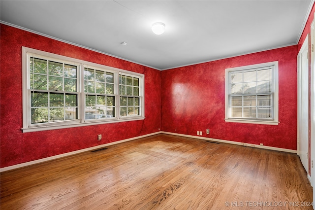 spare room featuring crown molding and wood-type flooring