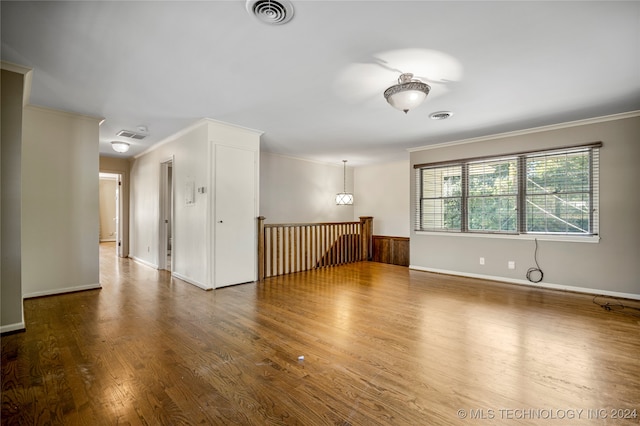 empty room featuring crown molding and wood-type flooring