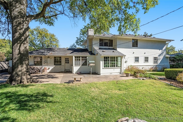 back of property with a patio area and a yard