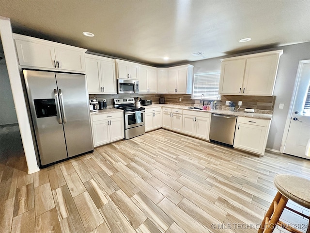 kitchen featuring stainless steel appliances, sink, and light wood-type flooring