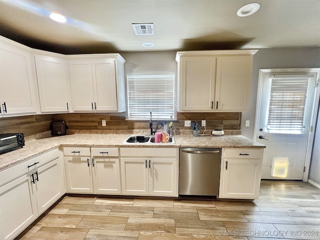 kitchen with white cabinetry, dishwasher, and sink