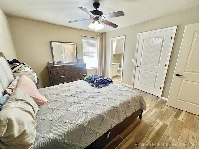 bedroom with ensuite bathroom, light hardwood / wood-style floors, and ceiling fan