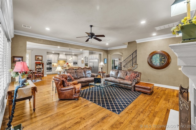 living room featuring crown molding, light wood-type flooring, and ceiling fan