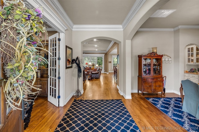 entrance foyer featuring crown molding and wood-type flooring