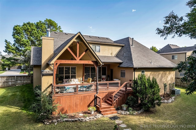 back of property with a wooden deck and a lawn