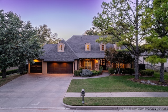 view of front of home featuring a garage and a lawn