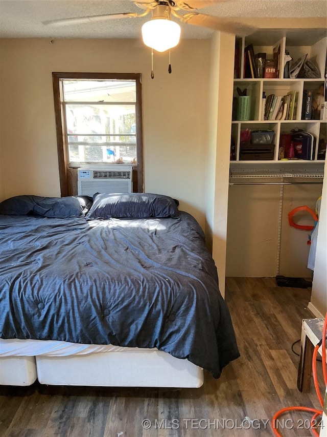 bedroom with a ceiling fan, cooling unit, and wood finished floors