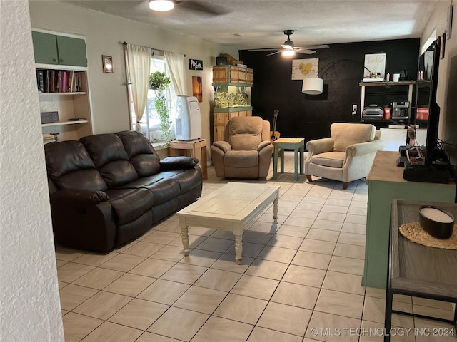 living area featuring light tile patterned floors, ceiling fan, and a textured ceiling