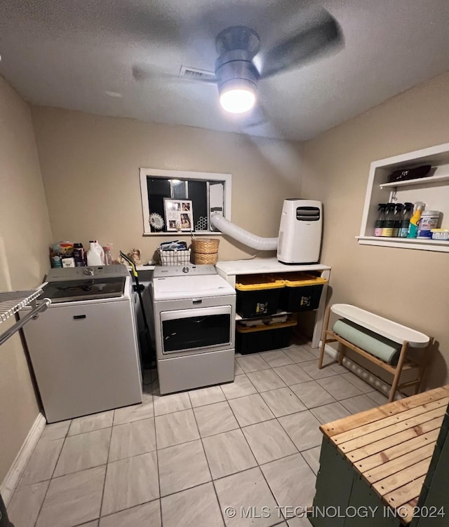 clothes washing area featuring washer and clothes dryer, light tile patterned floors, a ceiling fan, a textured ceiling, and laundry area