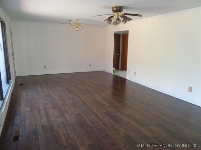 empty room featuring ornamental molding, dark wood-type flooring, and ceiling fan with notable chandelier