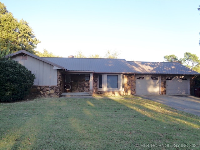 ranch-style home featuring a front lawn and a garage