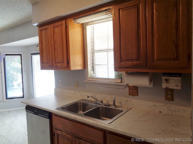 kitchen featuring stainless steel dishwasher, sink, and a textured ceiling