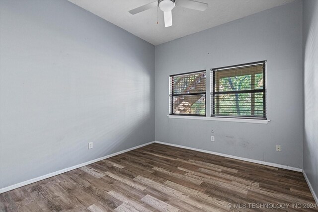 spare room with dark hardwood / wood-style floors and ceiling fan