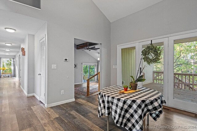 dining space with ceiling fan, dark hardwood / wood-style flooring, and high vaulted ceiling