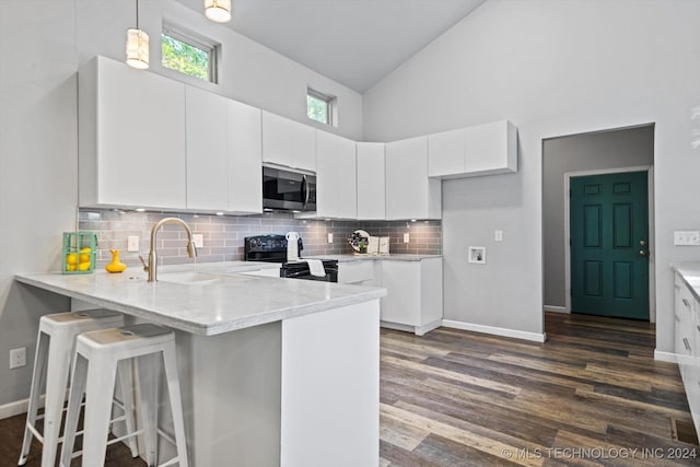 kitchen with dark wood-type flooring, high vaulted ceiling, hanging light fixtures, black range with electric cooktop, and white cabinetry