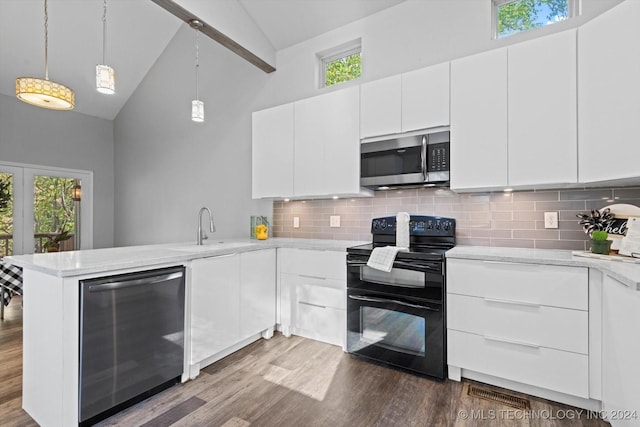 kitchen featuring double oven range, kitchen peninsula, sink, and white cabinets