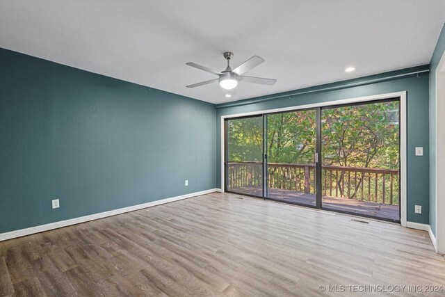 unfurnished room featuring hardwood / wood-style flooring, a wealth of natural light, and ceiling fan