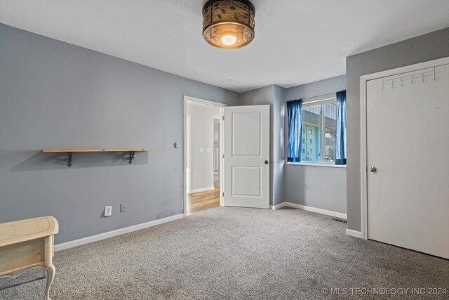 unfurnished bedroom featuring carpet floors and a closet